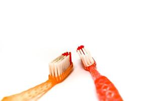 Two colorful toothbrushes face each other on a clean white surface, highlighting dental hygiene photo