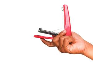 Close up of a hand holding a red stapler, ready to use, isolated on white background, in studio shot and product photography photo