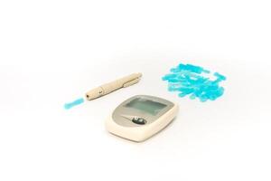 Essential diabetes management kit with lancet device, glucose meter and lancets on white backdrop photo