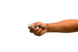 Close-up of a hand holding a small blue medical device on white background photo