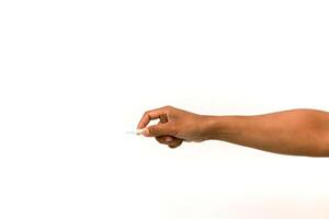 Close-up of hand holding small white object against a clean white background offering a simple visual aid photo