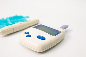 Close-up of Glucose Meter, Lancing Device, and Lancets on a White Background for Diabetes Testing photo