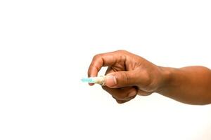 Close-up of a hand holding a lancet used for blood glucose testing isolated on a white background for diabetes management and health awareness photo