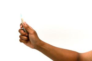 Close-up of hand holding lancet device for blood sugar testing on white background photo