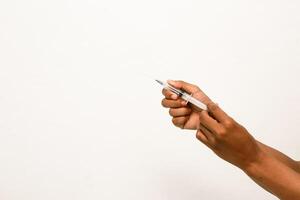 Close-up of hands holding a syringe against a white background, used for vaccination or medical treatment purposes photo