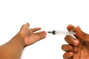A Person Getting Ready to Inject a Substance with a Syringe on a White Background photo