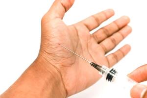 Close-up of needle injecting into hand palm, representing vaccination, blood testing, or medical procedure in a clinical setting photo