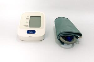 Digital blood pressure monitor on white background, used for health monitoring photo