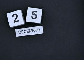 Calendar wood block December 25th Christmas Day on black background photo
