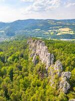 Panoramic view of the dry rocks of Suche skaly in Bohemian Paradise, Czechia. The sandstone formations rise dramatically from the lush green forest, creating a breathtaking landscape. photo