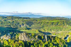 Visitors enjoy breathtaking vistas at Pantheon Lookout in Bohemian Paradise, overlooking lush greenery and the majestic Krkonose Mountains in the background. A perfect hiking destination. photo