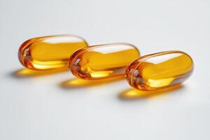 Three amber gel capsules isolated on white background photo