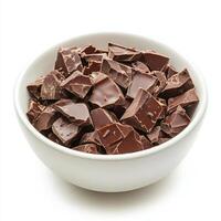 Dark chocolate chunks in white bowl isolated on white background photo