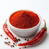 Red chili powder in bowl with peppers isolated on white background photo