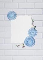 White Background With Blue Handmade Ranunculus Flowers and Empty Place for Text photo