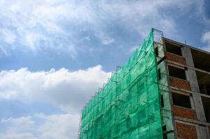 Building structure with netting shade and scaffolding covered photo