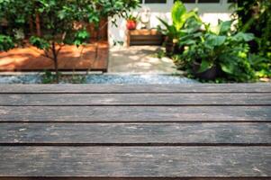 Empty dark hardwood table top on blurred garden background photo