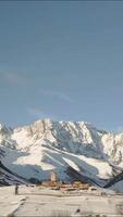 Aerial view Ancient Lamaria Monastery in snowy highland valley, surrounded by Caucasus peaks, part of UNESCO-listed Upper Svaneti region. video