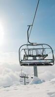 Ski chairlift moving fast in timelapse above fresh snow under cloudy sky with mountain peaks in winter Tetnuldi resort, Svaneti Georgia. video