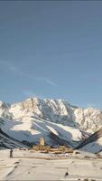 Aerial view beautiful Ancient Lamaria Monastery in snowy highland valley, surrounded by Caucasus peaks, part of UNESCO-listed Upper Svaneti region. video