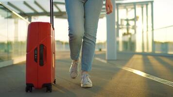 Woman confidently pulling a suitcase in an airport terminal. Slow motion video