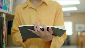 Close up man reading a book in library, turning pages, doing research video