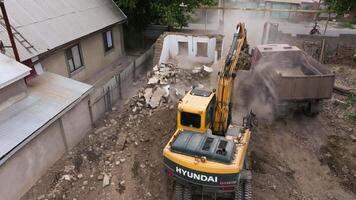 Aerial shot of a construction site featuring an excavator loading debris into a dump truck in Sokuluk, Kygryzstan - August 24, 2024 video