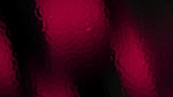 Dark crimson wavy glass texture suitable for background designs, digital art, product packaging, or website backgrounds that need a bold aesthetic. video