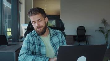 Fatigue at work in office, headache from overstrain. Focused employee cleaning glasses while seated at desk, working on laptop and contemplating various work tasks in stylish office environment video