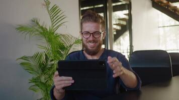 Young professional business consultant having pleasant online meeting using tablet, enjoying conversation and showcasing positive emotions in contemporary workspace. Successful business consultant video