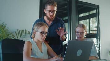 o negócio colegas colaborando em projeto, usando computador portátil e discutindo estratégias dentro moderno escritório ambiente, exibindo trabalho em equipe e problema resolução habilidades. o negócio desenvolvimento equipe video