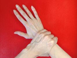 Hand gesture demonstrating support and connection on a vibrant red background photo
