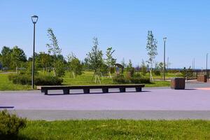 A modern and inviting park landscape featuring comfortable benches surrounded by lush greenery, photo