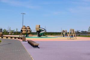 A Vibrant and Colorful Playground Featuring a Slide and Swings on a Bright Sunny Day photo