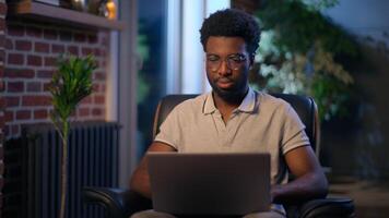African American guy student business man in night office businessman entrepreneur thoughtful male worker overtime evening laptop online working studying young designer programmer gamer computer using video