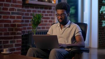 African American man businessman business employer typing laptop in night office overtime online studying deadline task in evening smiling guy male CEO manager programmer computer working web search video