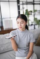 woman using smartphone while sitting on couch at home. photo