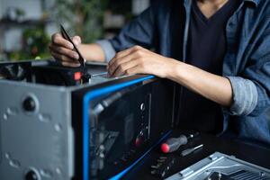 a Engineer man is working on a computer with a screwdriver photo