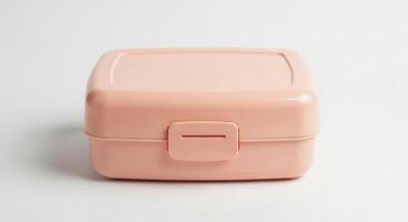 A close up view of a clean, pink lunch box isolated on a white background. photo