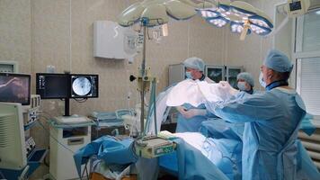 Professional medical team concentrating on performing surgery in modern operating room with advanced equipment, highlighting precision and teamwork in healthcare video