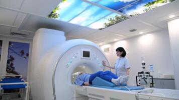 Medical professional carefully positioning patient on mri platform for precise diagnostic imaging within modern healthcare facility video