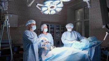 Professional medical team working collaboratively during laparoscopic surgery, demonstrating precision and expertise with advanced surgical equipment in sterile operating environment video