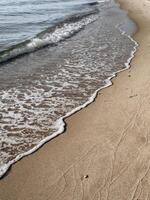 Soft sea foam reaches untouched sand creating a peaceful border between water and earth perfect for themes of balance mindfulness and slow living at the coast photo
