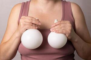 Woman Holds Silicone Breast Implants for Cosmetic Enhancement and Self-Expression photo