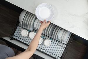 Organizing Clean Dishes in a Modern Kitchen Drawer With a Sleek Design and Efficient Layout photo