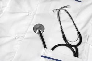 Stethoscope on a white medical gown background photo