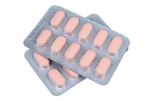Pink pills in a blister pack on a white background photo