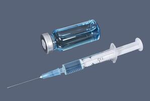 Syringe and phial with blue vaccine on the dark background photo