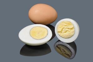 Slice boiled chicken eggs on gray background photo