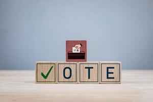 Wooden block with the letters VOTE and a check mark. Concept of election, political election campaign, voting and democratic rights exercise system photo